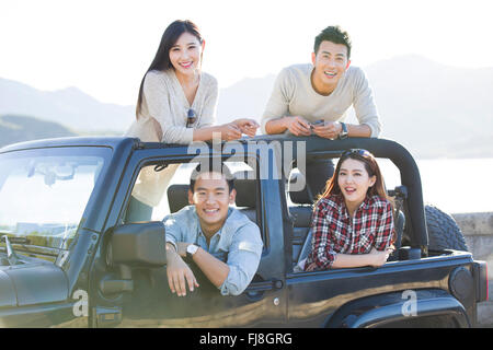 Amis chinois s'amusant dans une jeep Banque D'Images