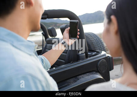 Jeune chinois couple taking self portrait with smart phone Banque D'Images