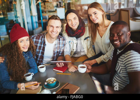Les adolescents Smiling at camera in cafe Banque D'Images