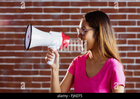 Asian woman criant dans un mégaphone Banque D'Images