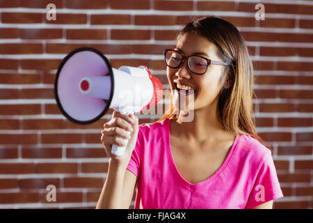 Asian woman criant dans un mégaphone Banque D'Images