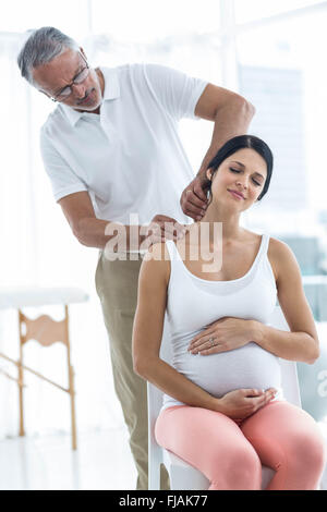 Doctor giving physiothérapie pour femme enceinte Banque D'Images