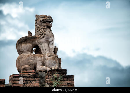 Statue du lion gardien du temple d'Abeyadana Bagan Myanmar // BAGAN, Myanmar — Une statue de lion gardien restaurée placée au sommet d'un éléphant orne le toit du temple d'Abeyadana (également connu sous le nom APE-Ya-da-na ou APE-Yadana-Phaya). Le temple date de la fin du XIe siècle ou du début du XIIe siècle et est situé près du temple Nagayon, juste au sud du village de Myinkaba dans la zone archéologique de Bagan. Le temple Abeyadana se distingue parmi les temples de l'ère païenne pour son imagerie bouddhiste Mahayana dans ses fresques, contrastant avec les thèmes Theravada plus communément trouvés dans d'autres temples de l'époque. Le temple présente SLO Banque D'Images