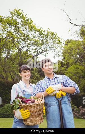 Young couple holding un panier de légumes fraîchement récoltés Banque D'Images