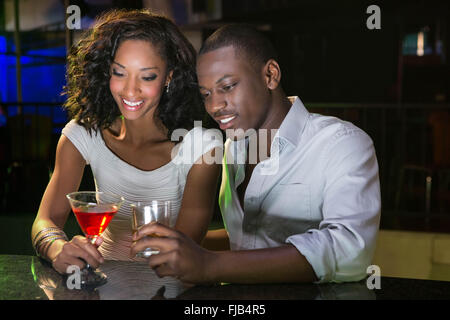 Couple ayant des boissons au comptoir du bar Banque D'Images