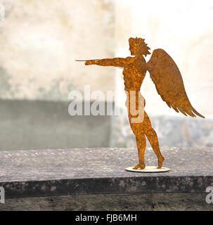 Fabriqué en métal, jeune homme avec des ailes se dresse sur un mur Banque D'Images