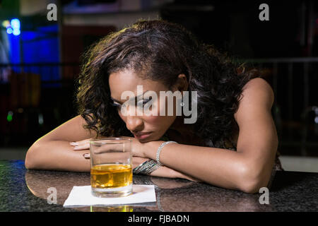 Femme ayant déprimé whisky au comptoir du bar Banque D'Images