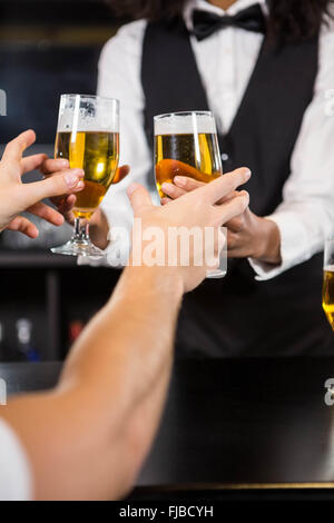 Female bartender servant de la bière au comptoir du bar Banque D'Images