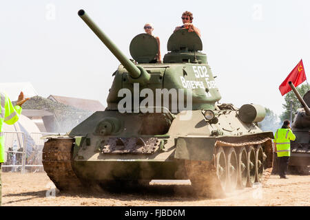 La guerre et la paix, l'Angleterre. Seconde Guerre mondiale char russe T-34 tank en voiture sur piste fermée et des coups de la poussière. L'homme et la femme à tourelle. Banque D'Images