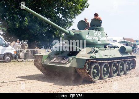 La guerre et la paix, l'Angleterre. Seconde Guerre mondiale char russe T-34 tank en voiture sur piste fermée et des coups de la poussière. L'homme et la femme à tourelle. Banque D'Images