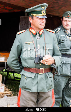 La guerre et la paix. L'Angleterre. WW2 re-enactment. Beau Général Allemand debout face à, pas de contact avec les yeux. La tenue des jumelles, une main dans l'arrière. Banque D'Images