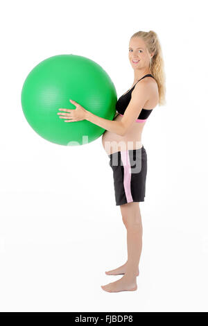 Pregnant woman holding yoga équilibre balle contre son ventre. Banque D'Images