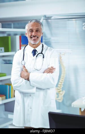 Doctor standing with arms crossed in clinic Banque D'Images