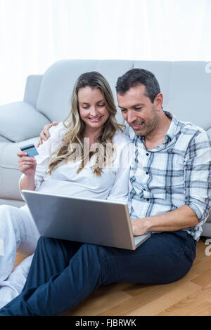 Expecting couple sitting on sofa Banque D'Images