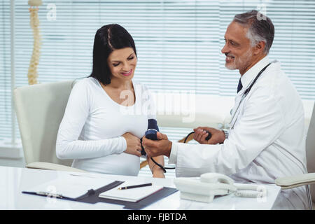 Médecin à mesure de la pression de la femme enceinte Banque D'Images