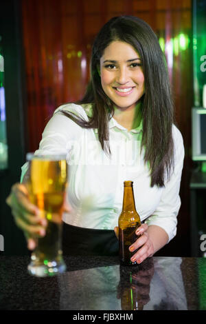 Portrait de jolie barman servant de la bière au comptoir du bar Banque D'Images