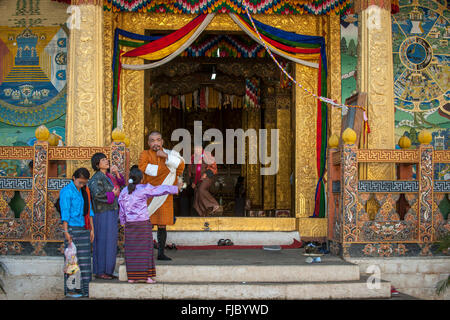 La famille vêtements traditionnels à l'entrée du temple, district de Punakha Dzong, Himalaya, Royaume du Bhoutan Banque D'Images