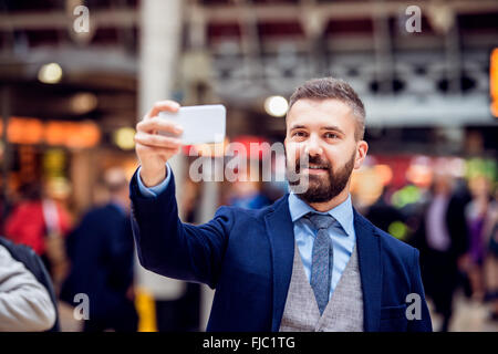 Homme d'Hipster avec smartphone prendre train bondé, selfies Banque D'Images