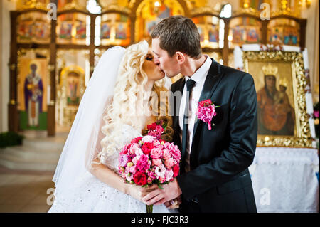 Le baiser de couple de mariés à l'église Banque D'Images