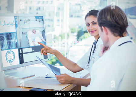 Image composite du docteur montrant l'écran d'un ordinateur à un collègue Banque D'Images