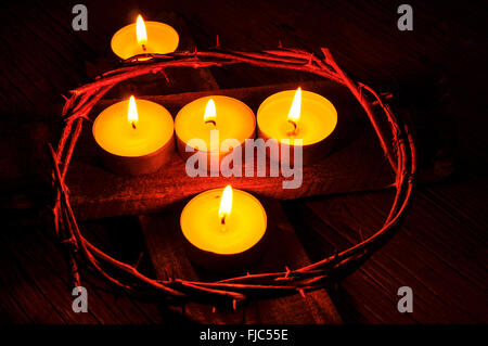 Libre d'une reconstitution de la couronne d'épines de Jésus Christ et quelques bougies allumées sur une croix en bois Banque D'Images