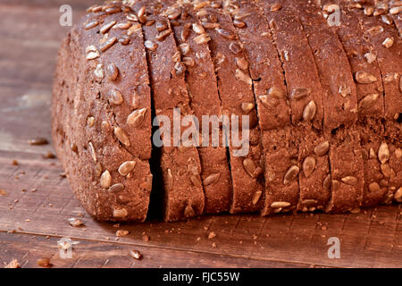 Libre de tranches de miche de pain de seigle garnies de graines de tournesol sur une surface en bois rustique Banque D'Images