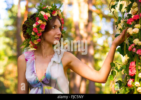 Belle femme dans la guirlande de roses. Banque D'Images