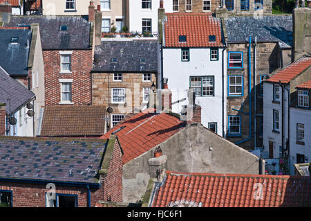 Vue rapprochée de terrasses en pierre et ardoise gris avec des toits rouges pantiled construit sur la colline de Staithes, Yorkshire du Nord Banque D'Images