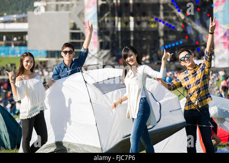 Amis chinois la mise en place d'une tente sur l'herbe Banque D'Images