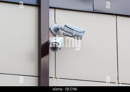 Deux caméras de sécurité sur un mur beige Banque D'Images