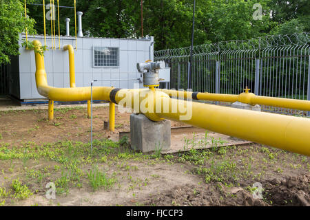 Les tuyaux de gaz jaune derrière une clôture de barbelés Banque D'Images