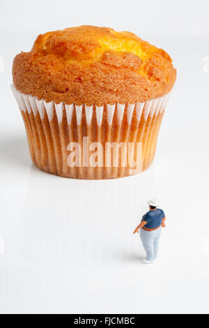 L'excès de l'homme à la recherche jusqu'à un très grand format ou une partie muffin concept l'obésité Banque D'Images