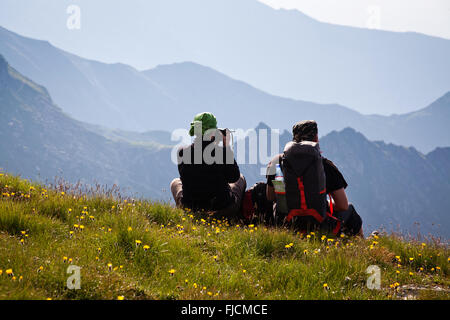 Les randonneurs de couple admiring view et prendre des photos de hautes montagnes Banque D'Images