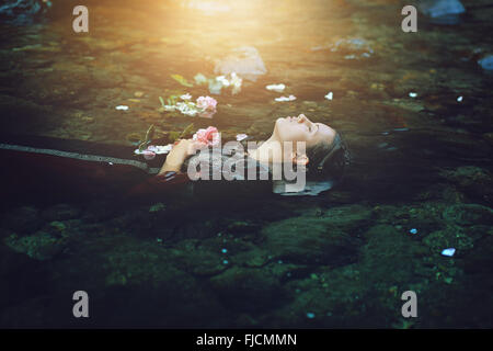 Femme morte flottant dans la rivière sombre . Conceptuel Ophelia Banque D'Images