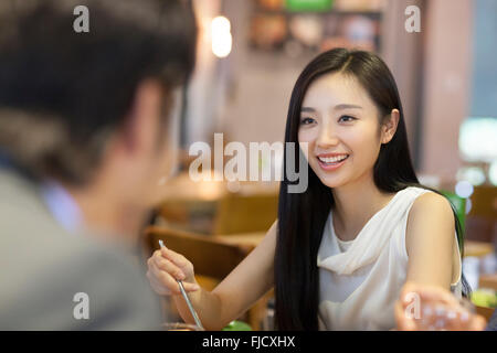 Jeune femme chinoise en train de dîner avec des amis Banque D'Images