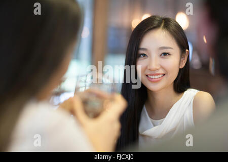 Jeune femme chinoise en train de dîner avec des amis Banque D'Images