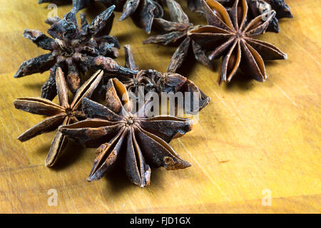 Les fruits et graines d'anis étoilé vietnamiens (Illicium verum) disposés sur un plan de travail en bois/surface. Banque D'Images