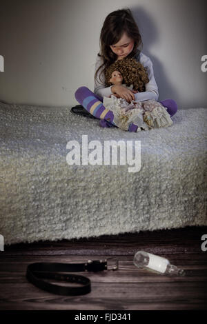 La violence dans la famille - peur little girl sitting on bed Banque D'Images