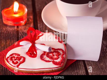 Saint Valentin romantique dessert avec une note emty, tasse de café et une bougie. Surprise pour un être cher. Profondeur de champ. Banque D'Images