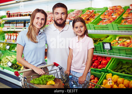 Jeune famille shopping pour les légumes dans un magasin Banque D'Images