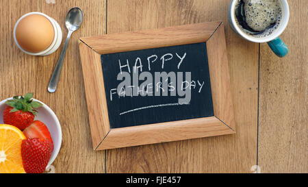 Heureux le jour de père écrit sur une ardoise entre un petit-déjeuner pour lui Banque D'Images