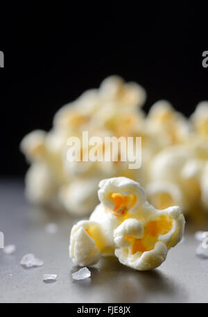 Popcorn et le sel isolé sur fond noir Banque D'Images