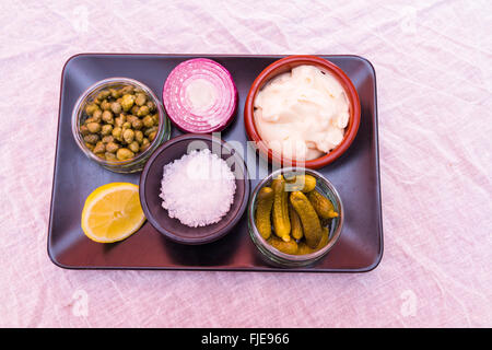 Le bac avec des ingrédients pour faire la sauce tartare, mayonnaise, sel, cornichons, câpres, oignons et citron Banque D'Images