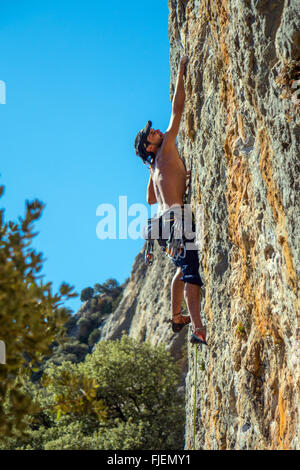 Male rock climber sur falaise calcaire abrupte Espagne Banque D'Images