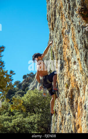 Male rock climber sur falaise calcaire abrupte Espagne Banque D'Images