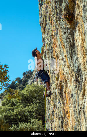 Male rock climber sur falaise calcaire abrupte Espagne Banque D'Images