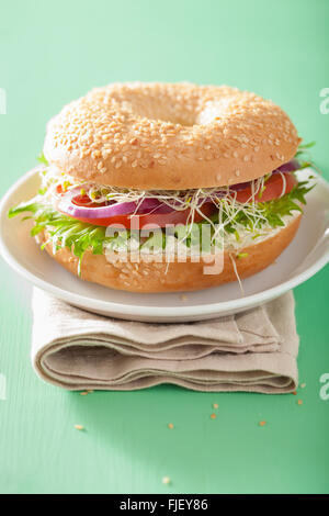 Le sandwich tomate bagel avec fromage à la crème de laitue oignon luzerne Banque D'Images