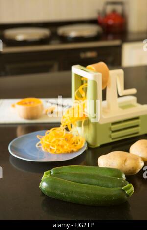 Spiralizing courge orange vif pour créer un repas sain et coloré qui pourrait tromper les enfants à manger des nouilles. Banque D'Images