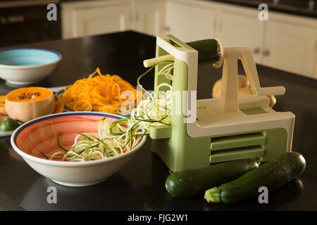 Spiralizing ou courgette courgette dans un chalet cuisine pour créer des repas sains pour les enfants qui n'aiment pas les légumes. Banque D'Images