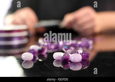 Améthyste, un beau collier violet. Enfiler des perles, atelier de joaillerie. La création de bijoux. Banque D'Images